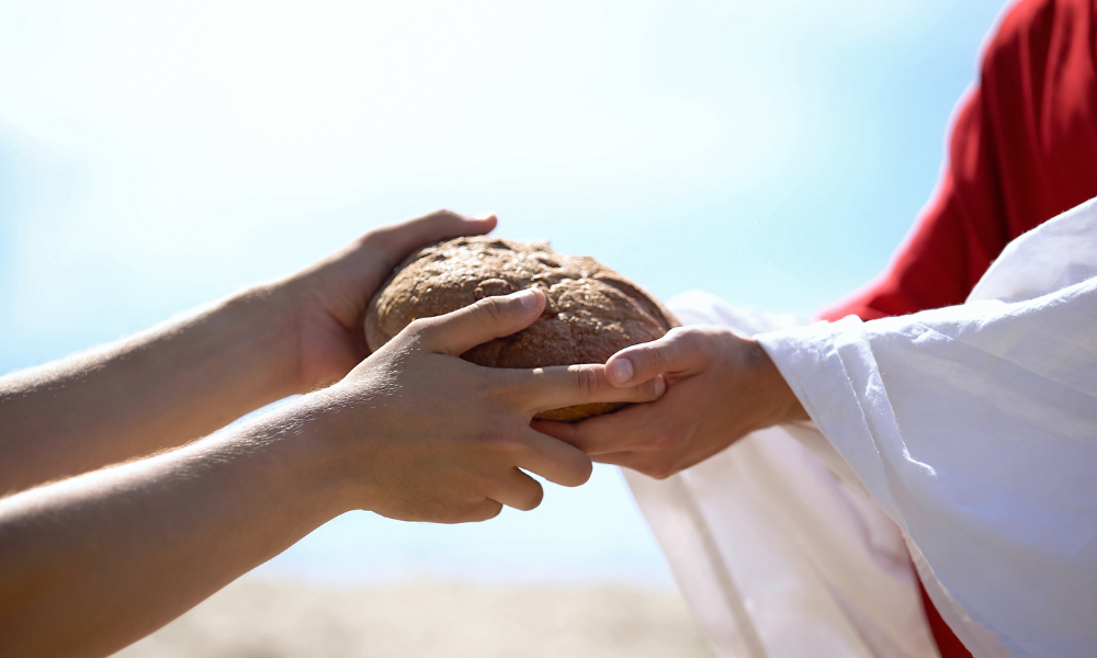 Robed person giving someone a loaf of bread